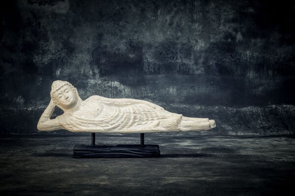 Sleeping Buddha on wooden stand
