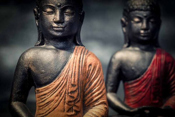 Sitting Buddha folded hands details red orange