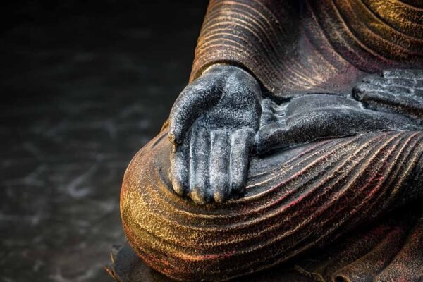 Sitting Buddha open hands details knee