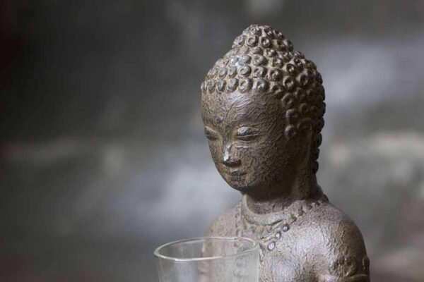 sitting Buddha on base with candle